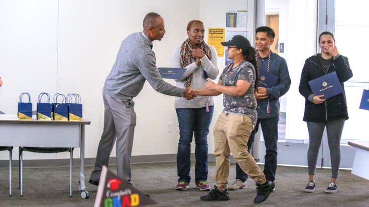 Students receiving graduation acknowledgements from staff