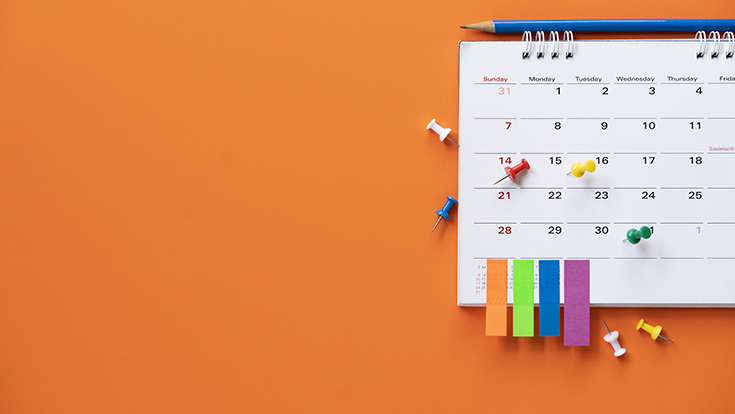 A paper calendar on an orange wall